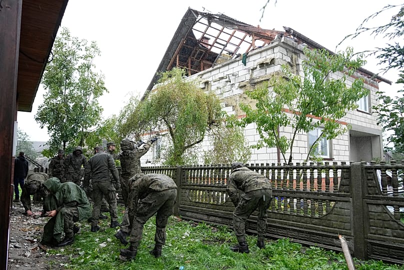 Territorial defence officers clean up debris from the destroyed roof of a house in Wyryki after Russian drones violated Polish airspace, 11 September, 2025