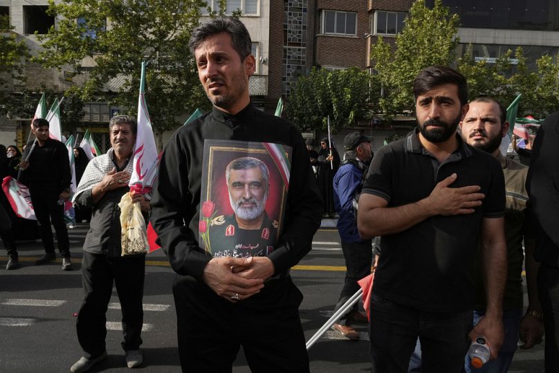 A man holds a picture of Iran's late head of the Revolutionary Guard’s ballistic missile program, Gen Amir Ali Hajizadeh during the funeral ceremony in Tehran, 28 June 2025