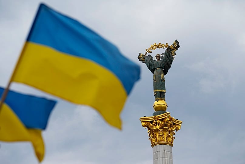 The Independence Monument is pictured as Ukrainian flags blow in the wind in Kyiv, 23 August 2025