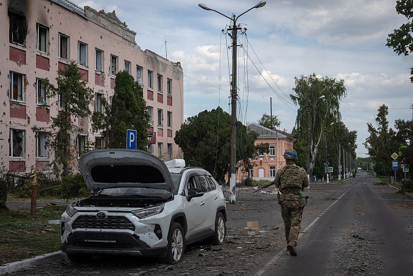 A Ukrainian soldier walks past at a city hall in Sudzha, 16 August, 2024
