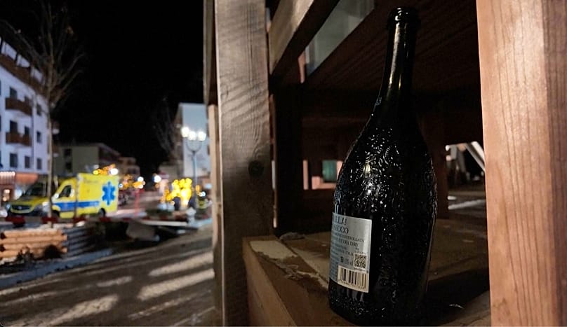 A bottle of sparkling wine lies where a fire broke out leaving people dead and injured, during New Year’s celebration, in Crans-Montana, Swiss Alps, 1 January 2026
