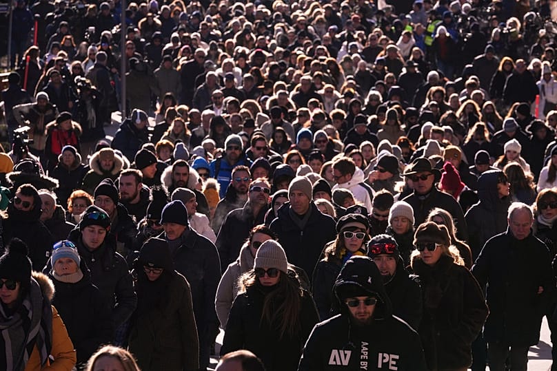 People walk during a memorial procession in after a devastating fire in Le Constellation bar killed 40 people, Crans-Montana, Swiss Alps, Switzerland, Sunday, Jan. 4, 2026