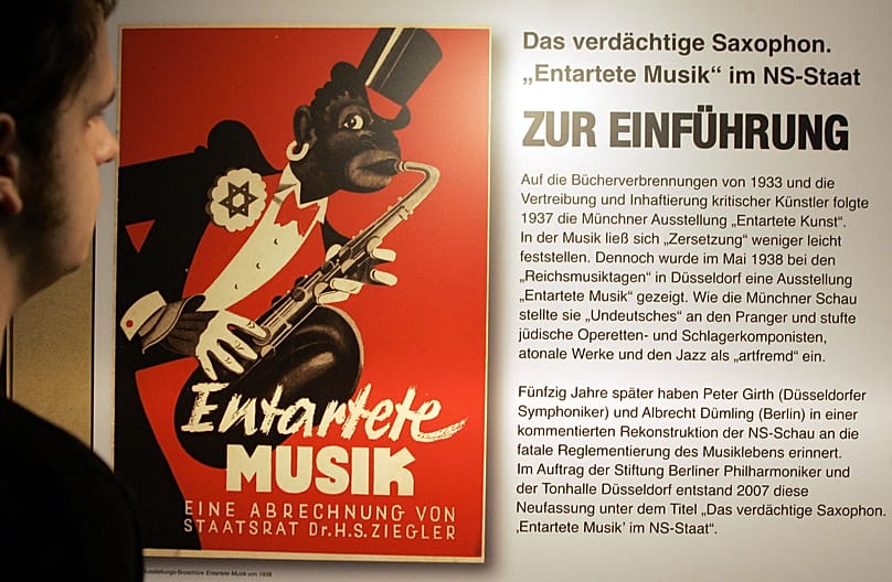 FILE: A man looks at a poster of an exhibition brochure from 1938 at the Berliner Philharmonie in Berlin on Friday, 2 November 2007.