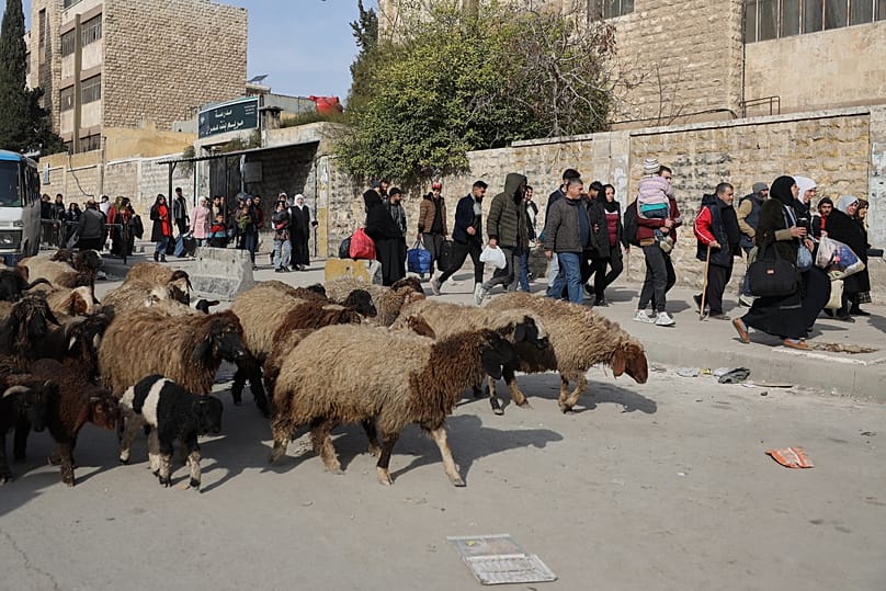 Residents carry their belongings as they are fleeing from Sheikh Maqsoud and Achrafieh neighbourhoods in Aleppo, 7 January, 2026