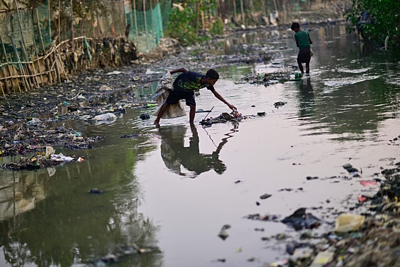 Rohingya refugees collect plastic waste from a drainage canal inside the refugee camp in Cox's Bazar, 22 November, 2025
