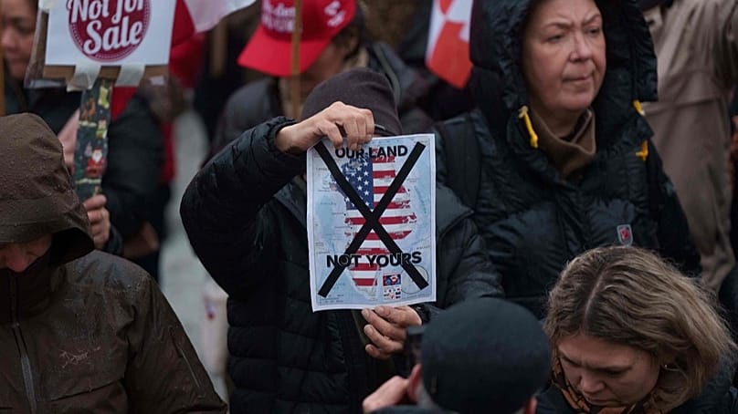 A man holds a map of Greenland covered in the American flag crossed out with an X during a protest against Trump's policy towards Greenland in Nuuk, 17 Jan, 2026.