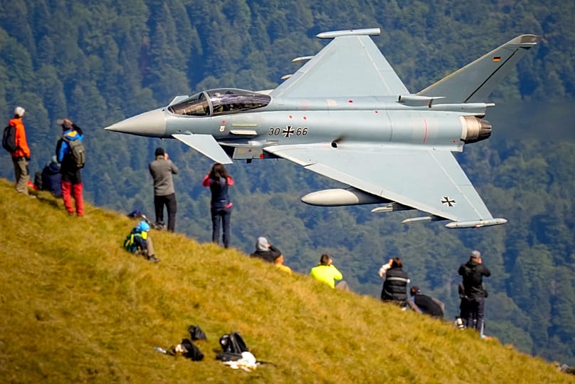 Aviation buffs observe an Eurofighter Typhoon German Airforce aircraft fly by in Busteni, 26 August, 2025
