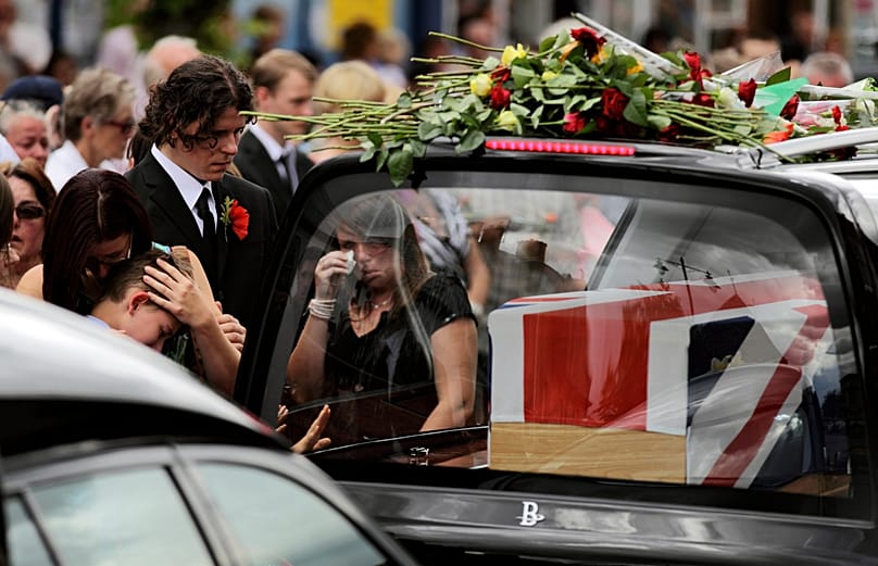 Mourners react as funeral hearses drive the coffins of four British soldiers through the town of Wootton Bassett, 22 July, 2010