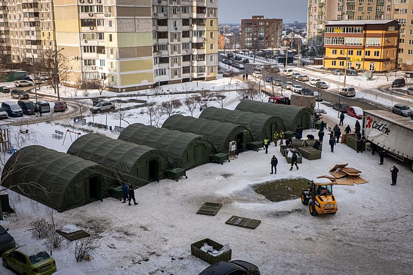 Emergency service workers set up tents where residents of neighbouring apartment buildings can warm up and sleep at night in Kyiv, 25 January, 2026