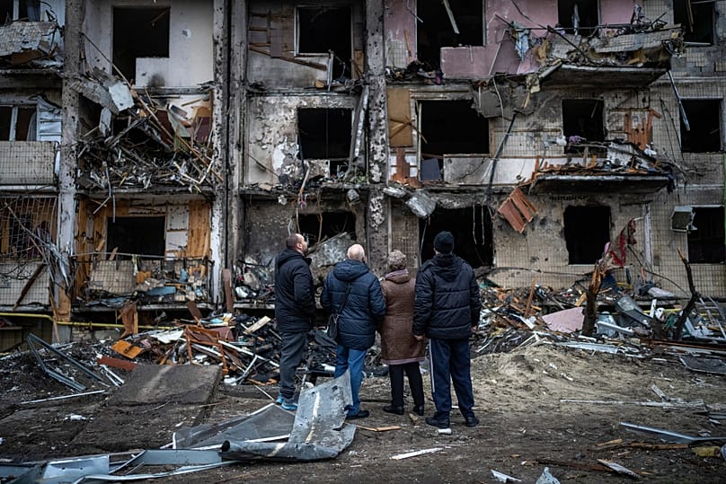 People look at the damage following a rocket attack the city of Kyiv, 25 February, 2022