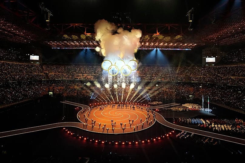 Fireworks explode by the Olympic rings during the Olympic opening ceremony at the 2026 Winter Olympics, in Milan, Italy, Friday, Feb. 6, 2026.