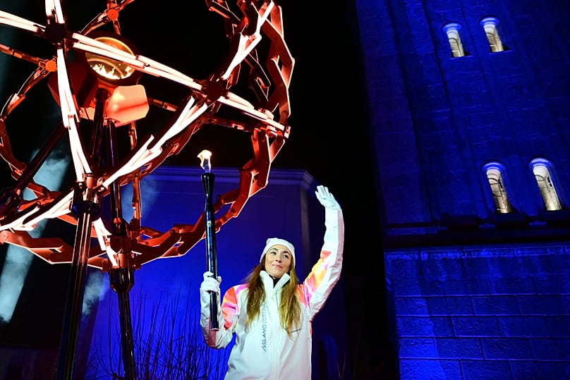 Final torchbearer Italian skier Sofia Goggia holds the torch of the Olympic flame to light the Olympic cauldron in Cortina d'Ampezzo, Italy, Friday, Feb. 6, 2026.