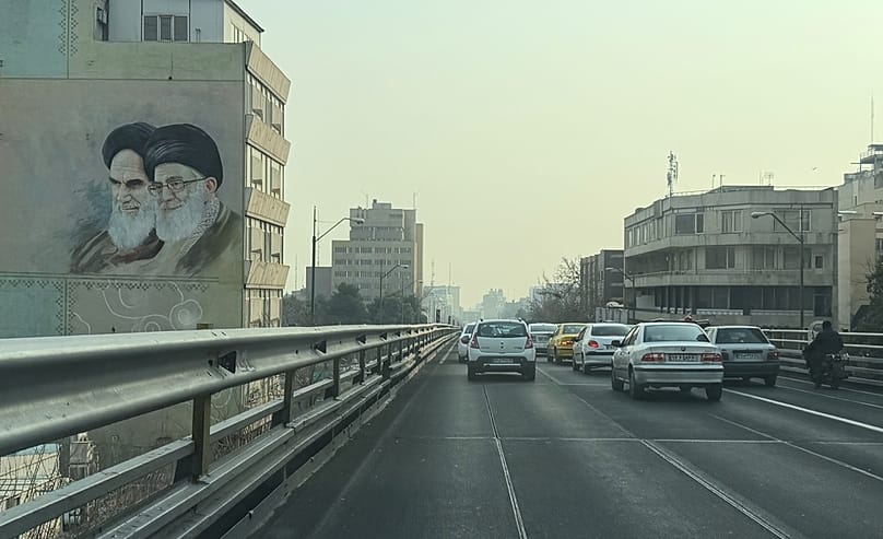 FILE: Vehicles drive past portraits of the late Iranian revolutionary founder Ayatollah Khomeini and Ayatollah Ali Khamenei, in downtown Tehran, 25 January 2026