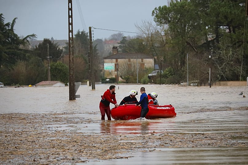 Members of the fire brigade push a rubber boat along a flooded road, as severe flooding hits western France amid storm Nils, in La Reole, Sunday, Feb. 15, 2026. (AP Photo/Yoha