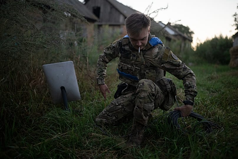 A Ukrainian serviceman nicknamed Bakeneko sets up satellite communications before a drone attack in the outskirts of Kremmina, Ukraine, Sunday, Aug. 20, 2023
