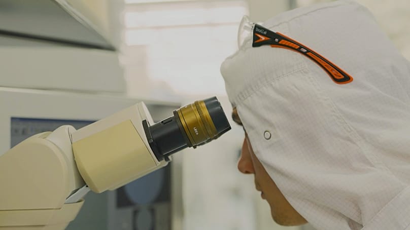 A technician inspects semiconductor materials at imec.