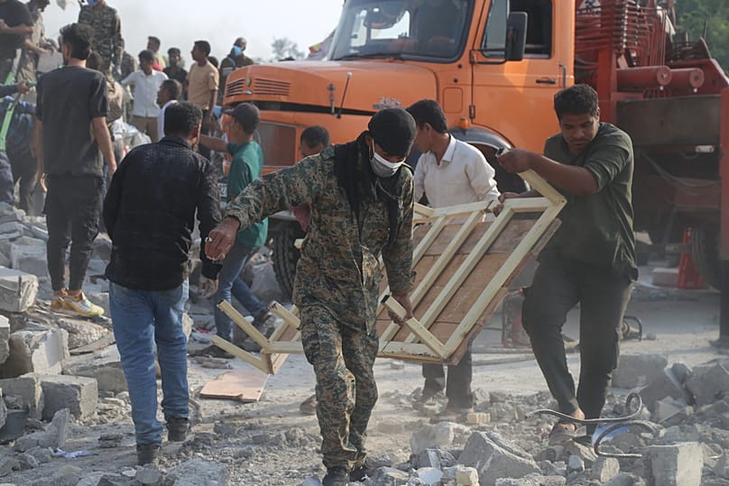 Rescue workers and residents remove rubble in the aftermath of what Iranian officials said was an Israeli-US. strike on a girls' elementary school in Minab, Iran
