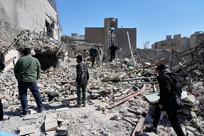 A group of men inspects the ruins of a police station in Tehran, 3 March, 2026