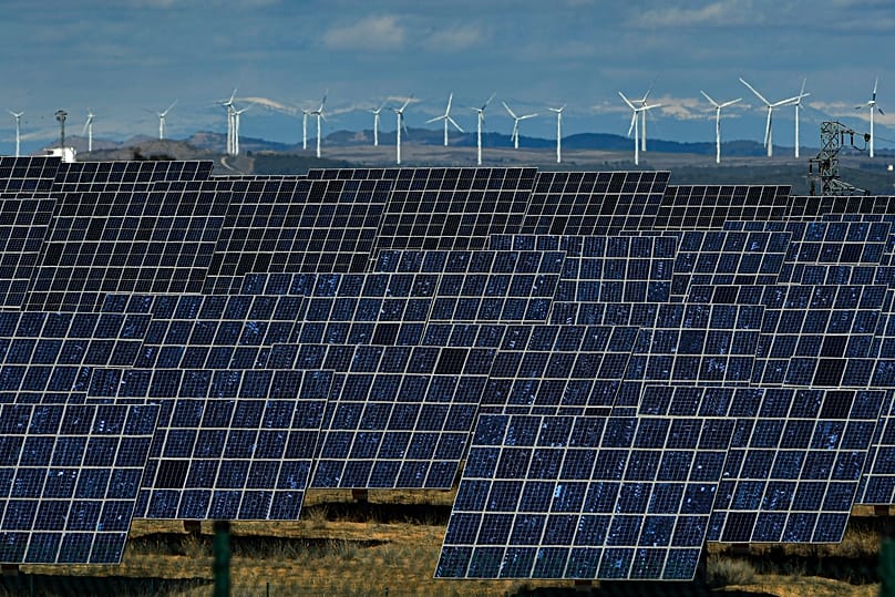 FILE - Solar panels work near the small town of Milagro, Navarra Province, northern Spain, Feb. 24, 2023.