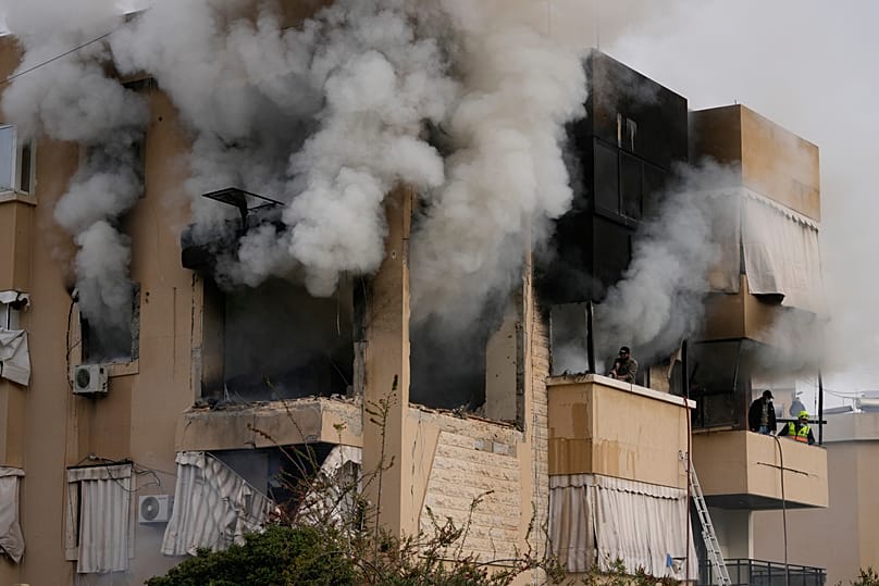 Rescue workers inspect an apartment damaged in an Israeli airstrike as thick smoke fills the building in the southern port city of Sidon, Lebanon, Saturday, March 14, 2026.