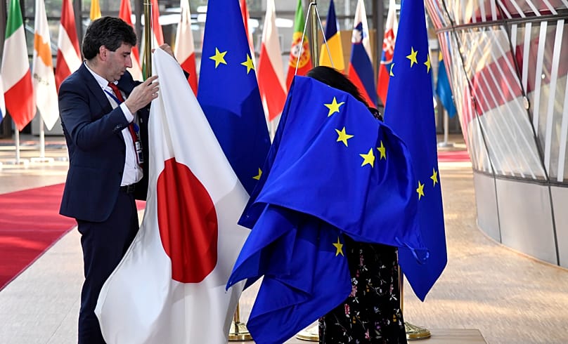 Members of protocol install the EU and Japanese flag ahead of the arrival of Japan's Prime Minister Fumio Kishida at the European Council building in Brussels, March 24, 2022.