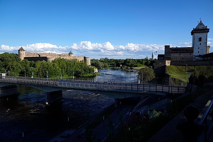 A bridge straddles Ivangorod, Russia on the left and a border crossing in Narva, 16 June, 2022