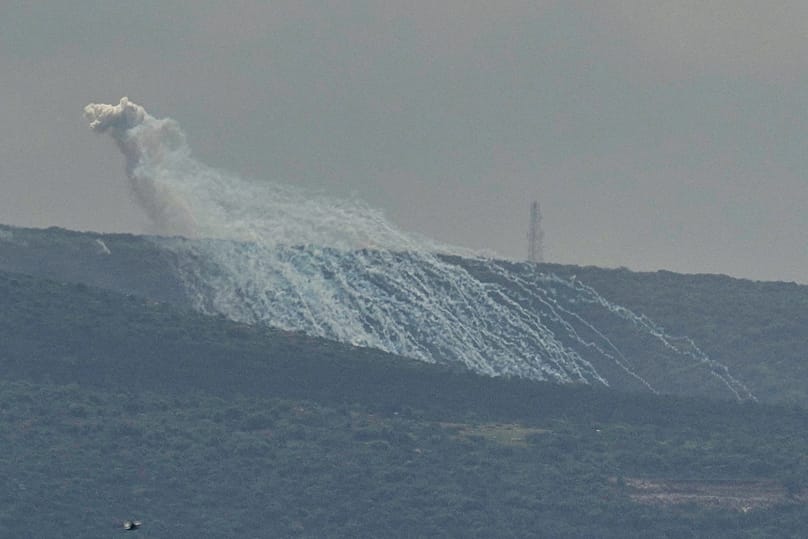 A shell that appears to be white phosphorus from Israeli artillery explodes over a road leading to Chamaa village, as it is seen from Tyre city, south Lebanon, March 27, 2026.