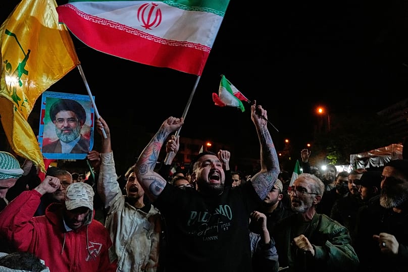 Pro-government demonstrators chant slogans as they hold Iranian flags in Tehran, 8 April, 2026