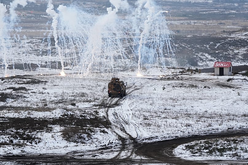 Soldiers drive a vehicle as they work to extract and secure an enemy in a mock village during NATO led military exercises at a military base near Bergen, 19 February, 2026