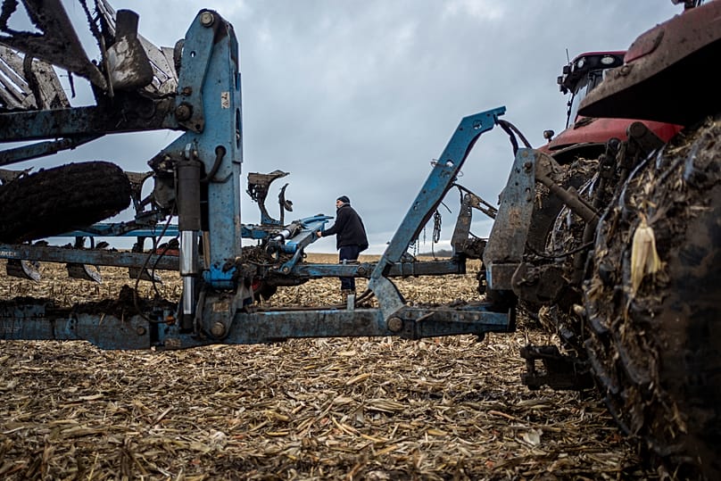 A farmer operates a tractor at a cornfield in Sumy region, 24 November, 2023