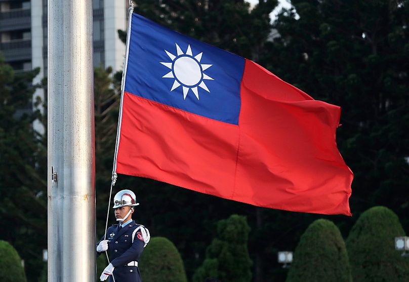 A soldier lowers the Taiwan national flag during the daily flag ceremony at the Chiang Kai-shek Memorial Hall in Taipei, 29 April, 2025