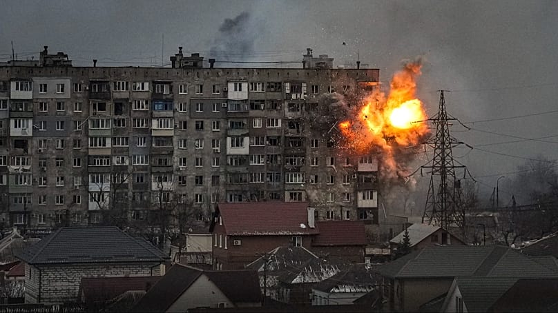 An explosion erupts from an apartment building at 110 Mytropolytska St., after a Russian army tank fired on it in Mariupol, Ukraine, Friday, March 11, 2022