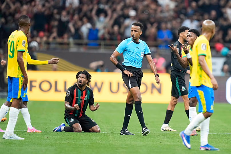 Referee Omar Artan, center, of Somalia, signals a penalty during the CAF Champions League final soccer match between AS FAR Rabat and Mamelodi Sundowns, in Rabat, Morocco.