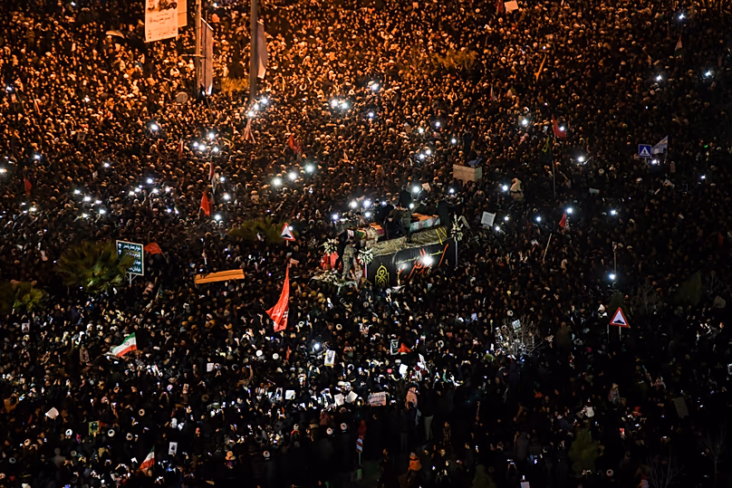 FILE: Mourners surround a truck carrying the flag-draped coffins of Gen Qassem Soleimani and his comrades in the holy city of Qom south of the capital Tehran, 6 January 2020
