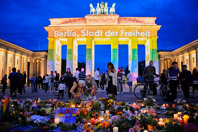 People gather in front of the Brandenburg Gate commemorating the victims, after a car rammed into a crowd at the Pride March in Berlin, Sunday, July 26, 2026.