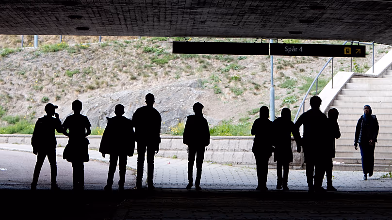 Migrants walk under a railway bridge in the town of Flen, roughly 100 kilometres west of Stockholm, Sweden, 30 August, 2018.