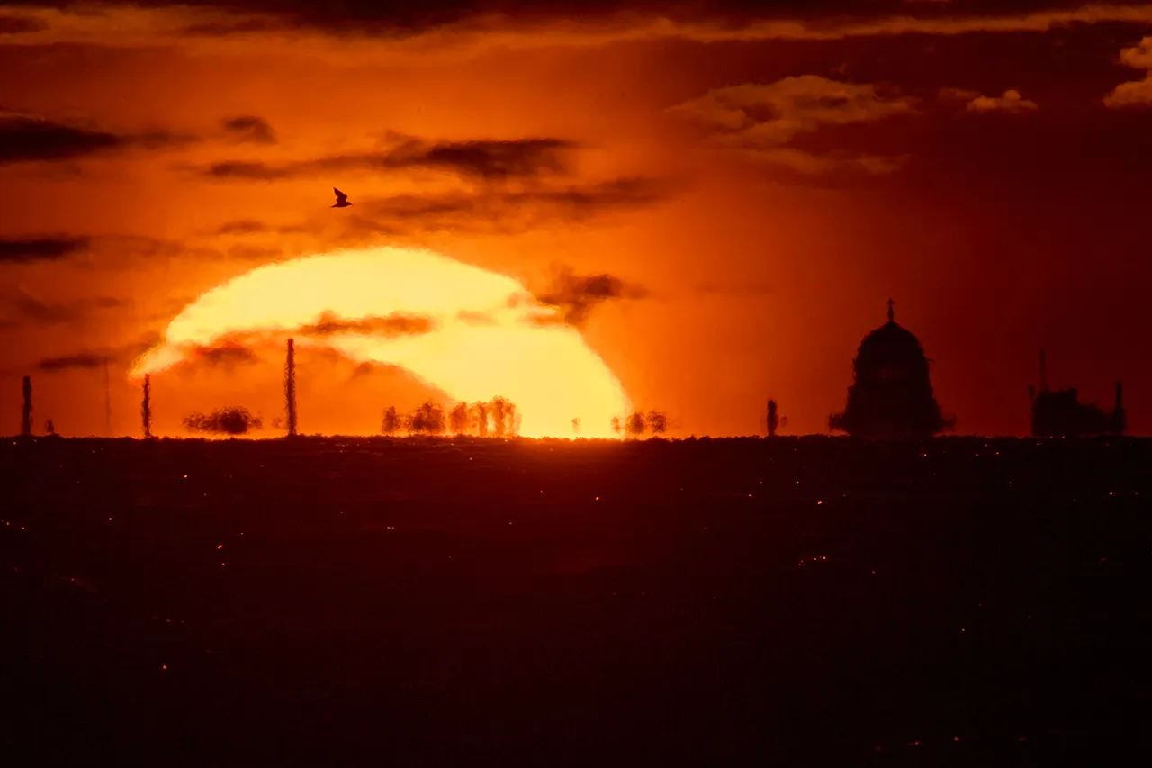 The moon and the sun set in the Gulf of Finland, during a solar eclipse in St. Petersburg, Russia