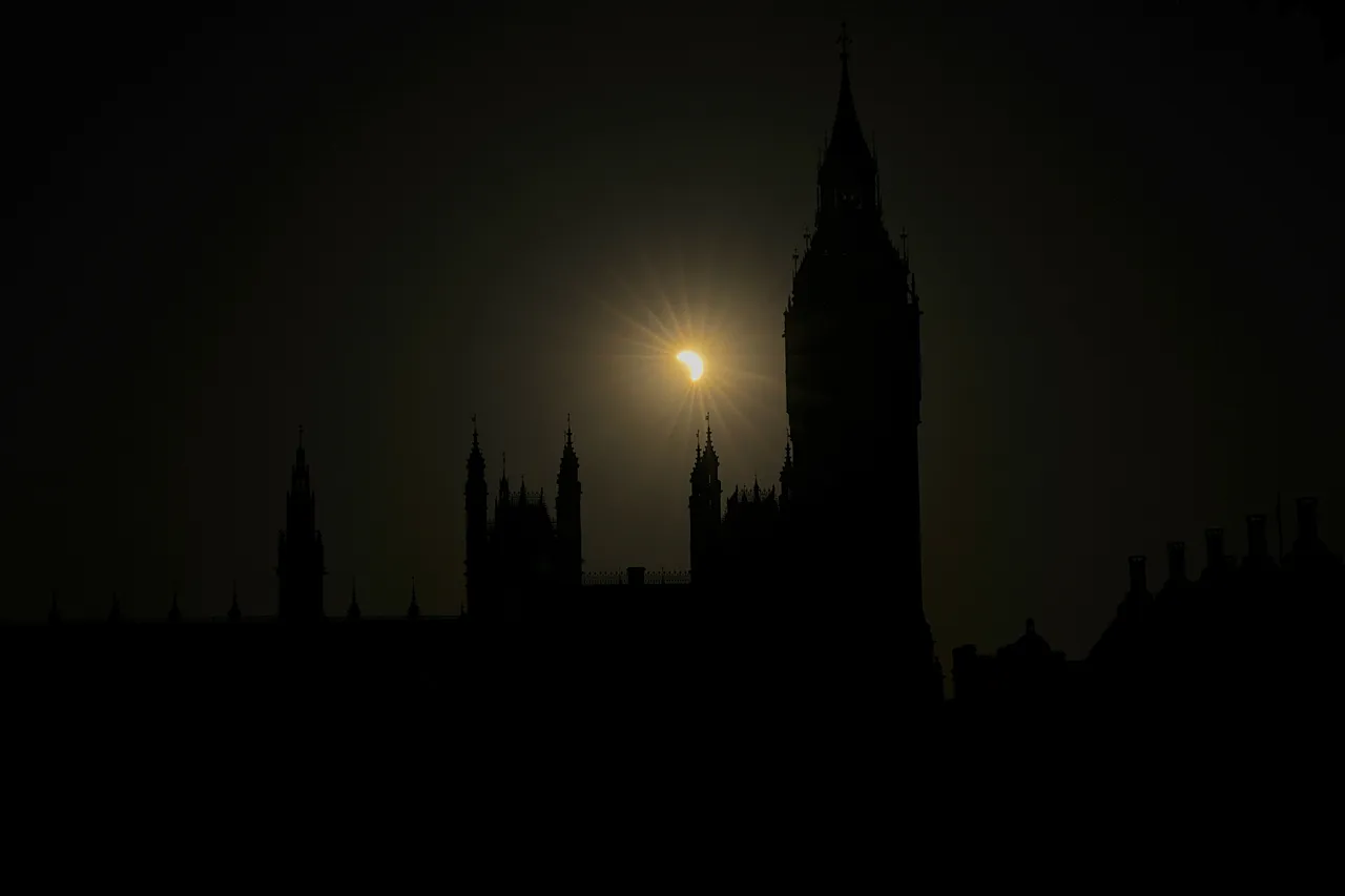 A partial solar eclipse is seen above the Houses of Parliament in London