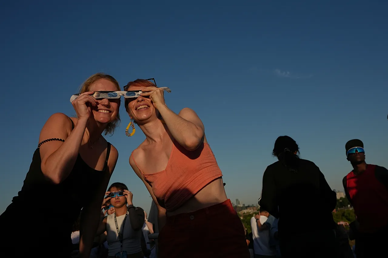 People watch the solar eclipse on Primrose Hill in London