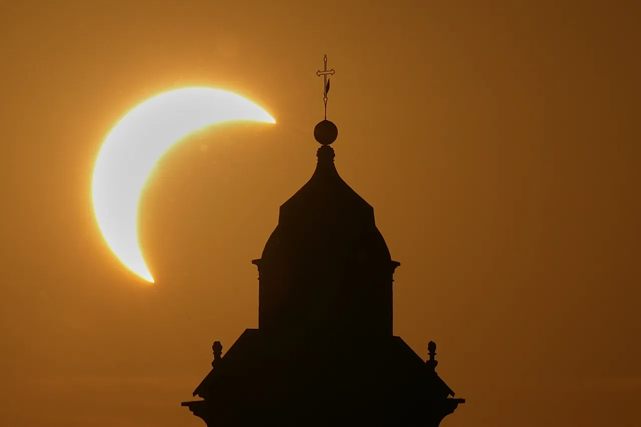 A solar eclipse is seen over a Virgin Maria church in Vidigulfo, near Pavia, northern Italy