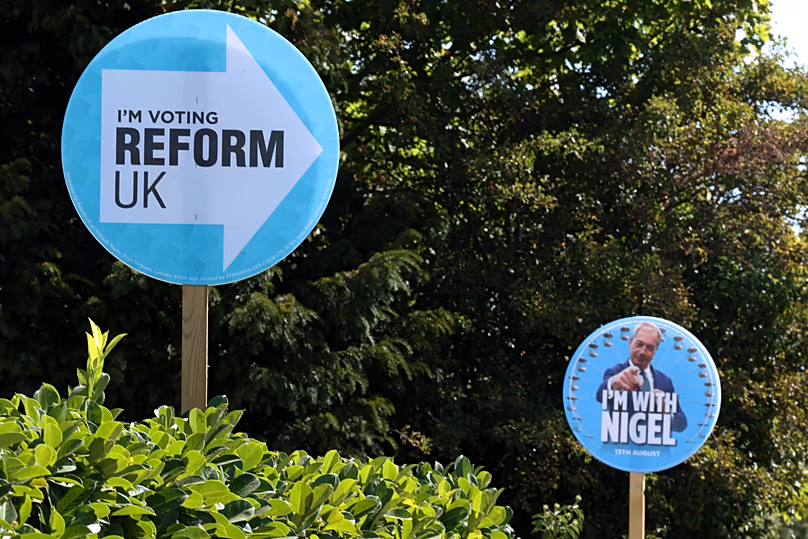 Election signs for Reform UK party leader Nigel Farage are seen in gardens in Thorpe-Le-Soken, 13 August, 2026