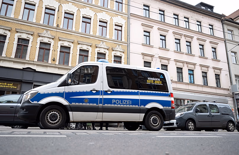 Police officers stand near to a police vehicle in front of a house in Leipzig Connewitz, 24 April, 2024