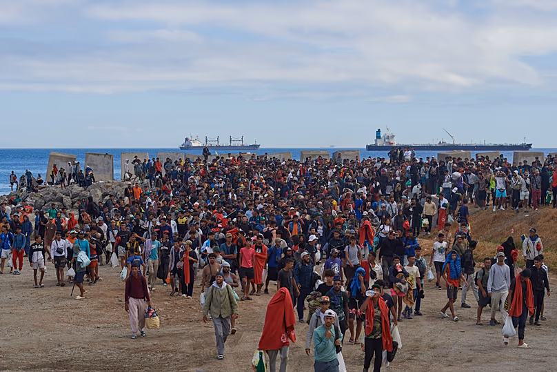 Migrants who crossed from Morocco into Spain are escorted by Spanish police to temporary shelters after being cleared from a beach where migrants sleep at Ceuta, 21 August, 2026