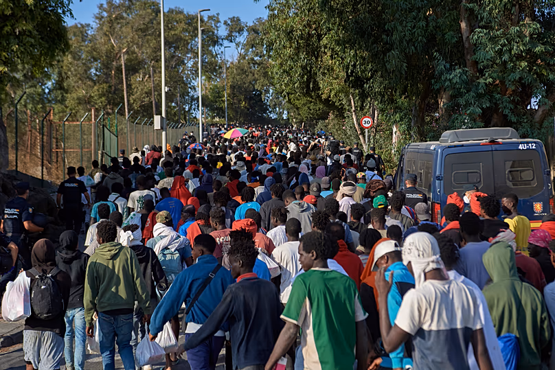 Migrants who crossed from Morocco into Spain are escorted by Spanish police to temporary shelters after being cleared from a beach in Ceuta, 20 August, 2026