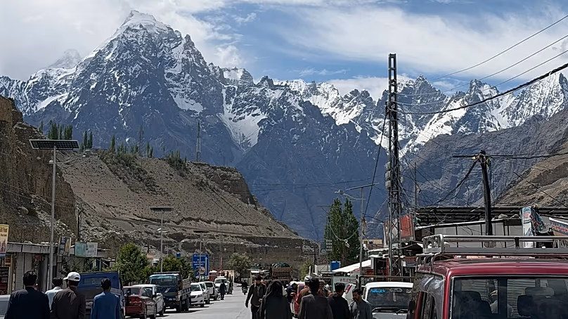 People walking through the village of Sost, with a vast mountain range as backdrop in Upper Hunza, Gilgit-Baltistan, Pakistan. 12 June, 2026.