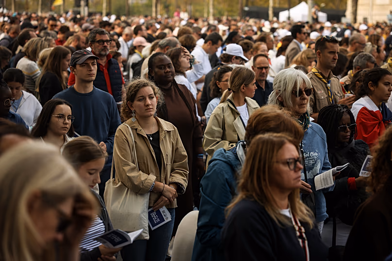 Faithful along on the Champs Elysees avenue follow a Mass celebrated by Pope Leo XIV at the Place de la Concorde in Paris, Saturday, Sept. 26, 2026. (AP Photo/Thomas Padilla)