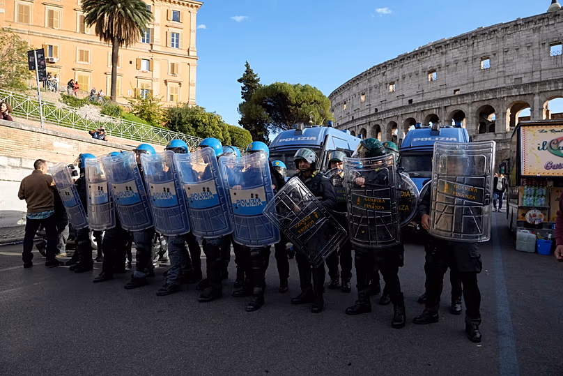 Italian anti-riot police watch antiwar activists demonstrating against rearmament and Italy's involvement in wars in Rome, Saturday, Oct. 24, 2026,